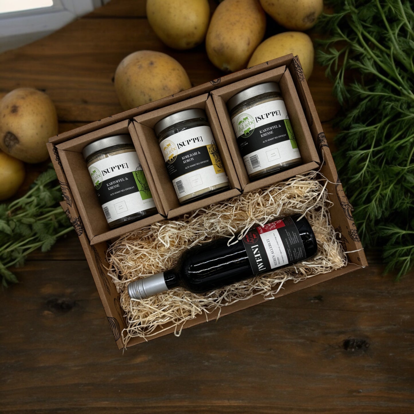 Ein schöner Präsentkorb der Marke elseLiebe in dem eine Flasche Rotwein liegt und darüber drei Gläser Suppe.