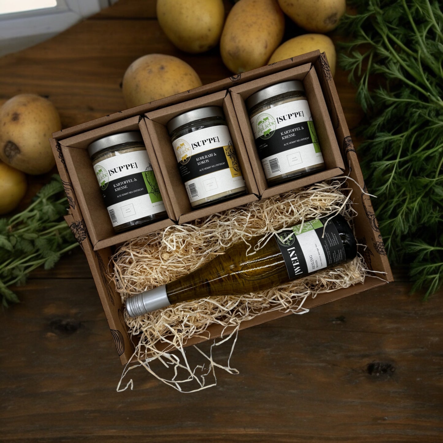 Ein schöner Präsentkorb der Marke elseLiebe in dem eine Flasche Weißwein liegt und darüber drei Gläser Suppe.