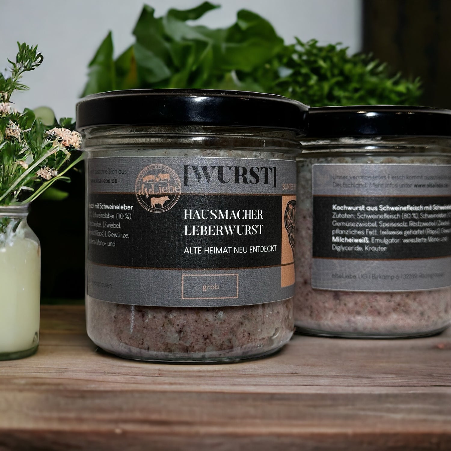 Zwei Gläser Hausmacher Leberwurst stehen auf einer dekorierten Arbeitsplatte.