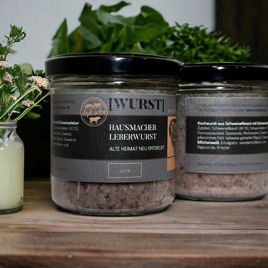 Zwei Gläser Hausmacher Leberwurst stehen auf einer dekorierten Arbeitsplatte.