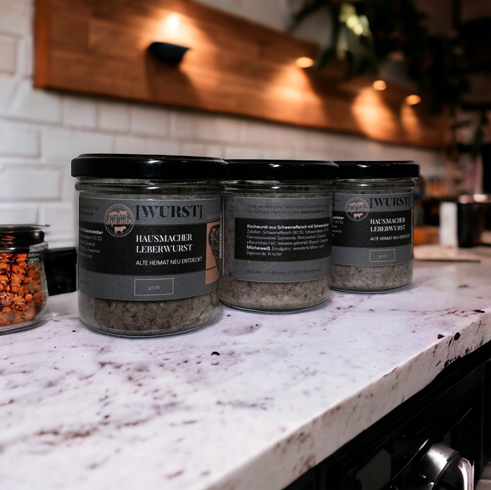 Drei Gläser Hausmacher Leberwurst stehen auf einer Arbeitsplatte. Die Marke elseLiebe ist zu erkennen.