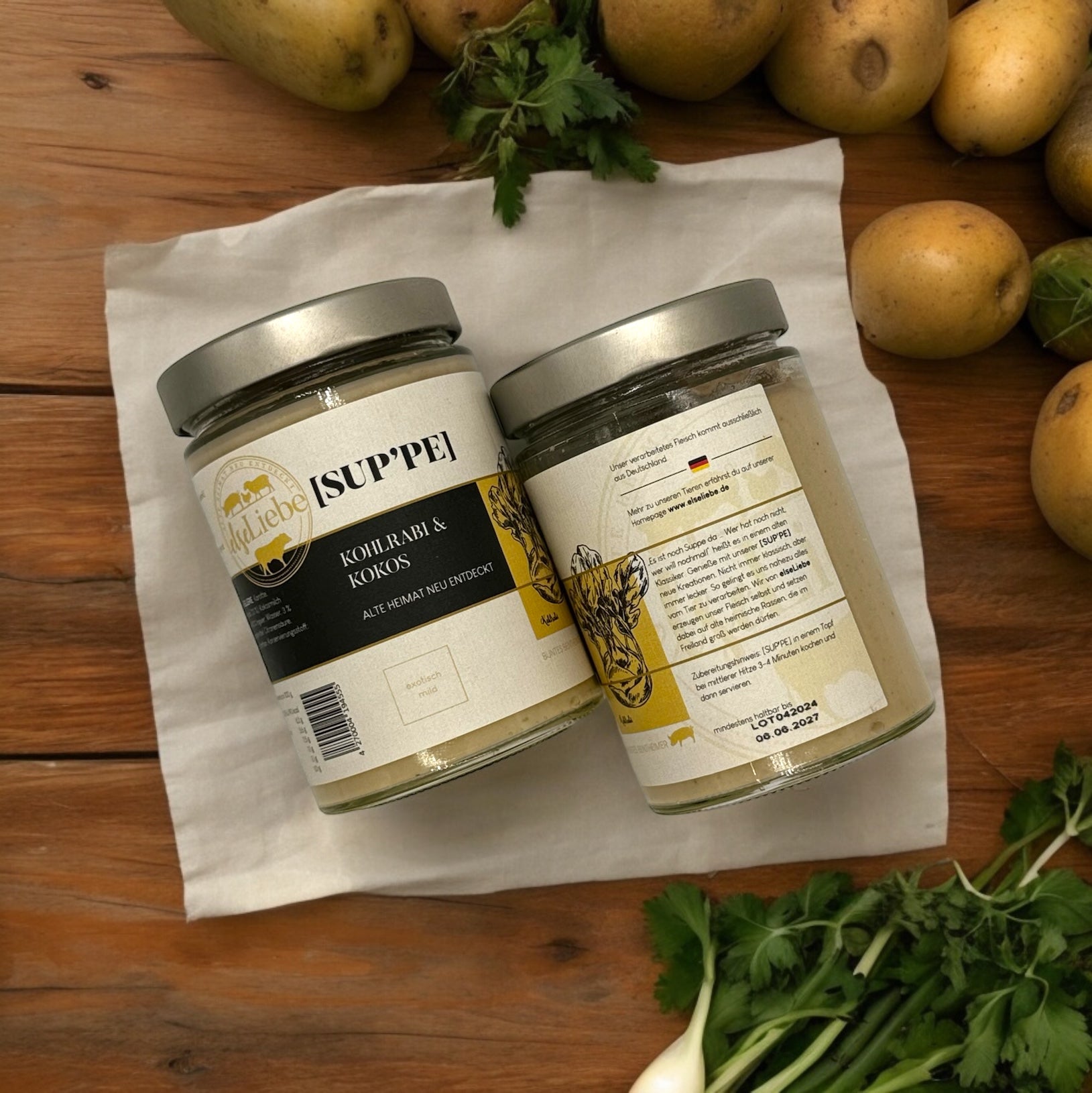 Auf dem Bild ist ein Glas mit der Suppe Kohlrabi & Kokos der Marke elseLiebe von oben fotografiert. Man sieht sowohl die Frontansicht des Etiketts, als auch die Rückseite.